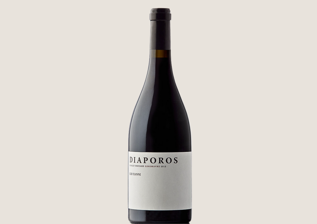 Flasche Diaporos Rotwein mit schlichtem weißen Etikett auf hellem Hintergrund.