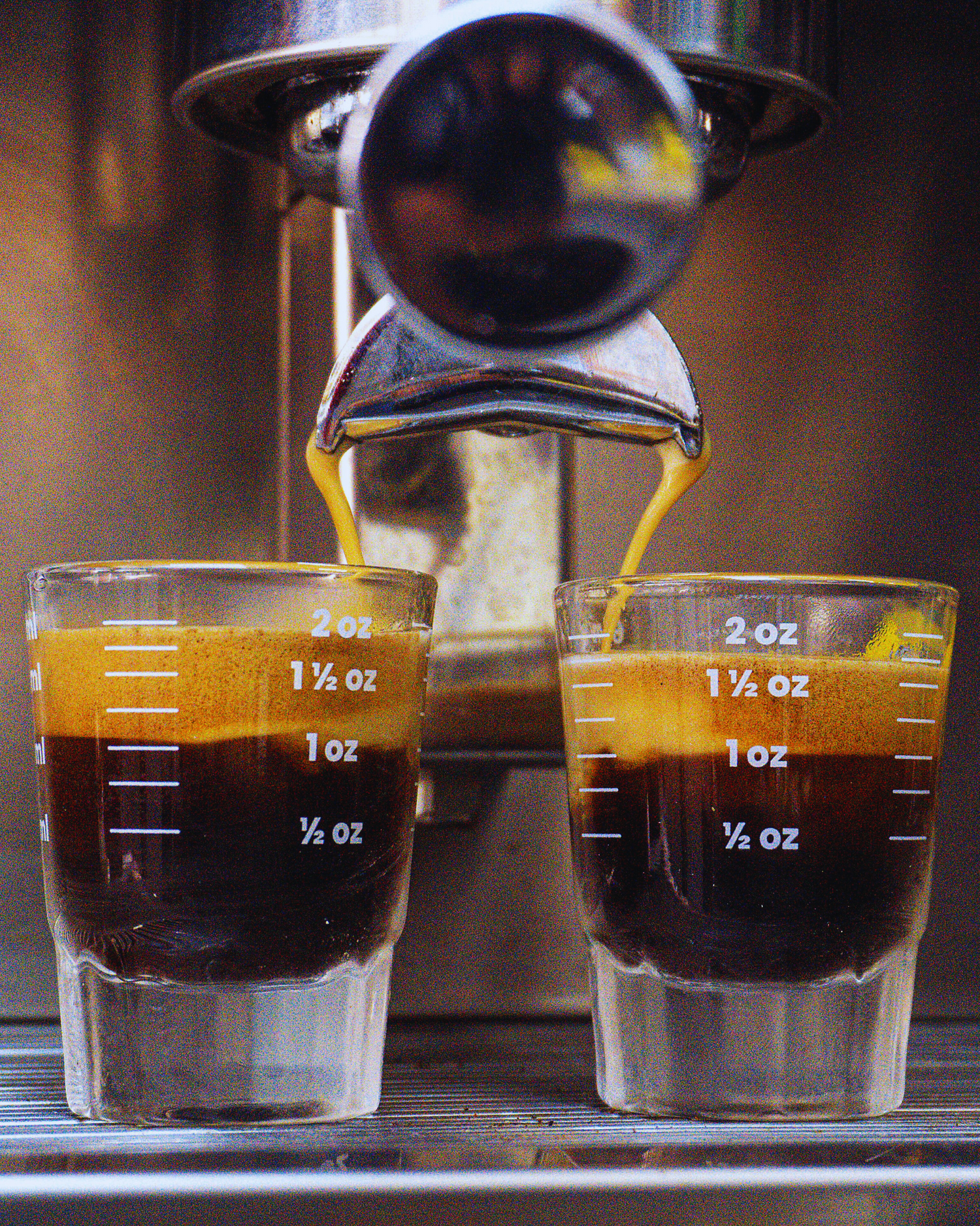 „Frisch gebrühter Espresso Doppio läuft in zwei Gläser mit Crema aus der Siebträgermaschine“