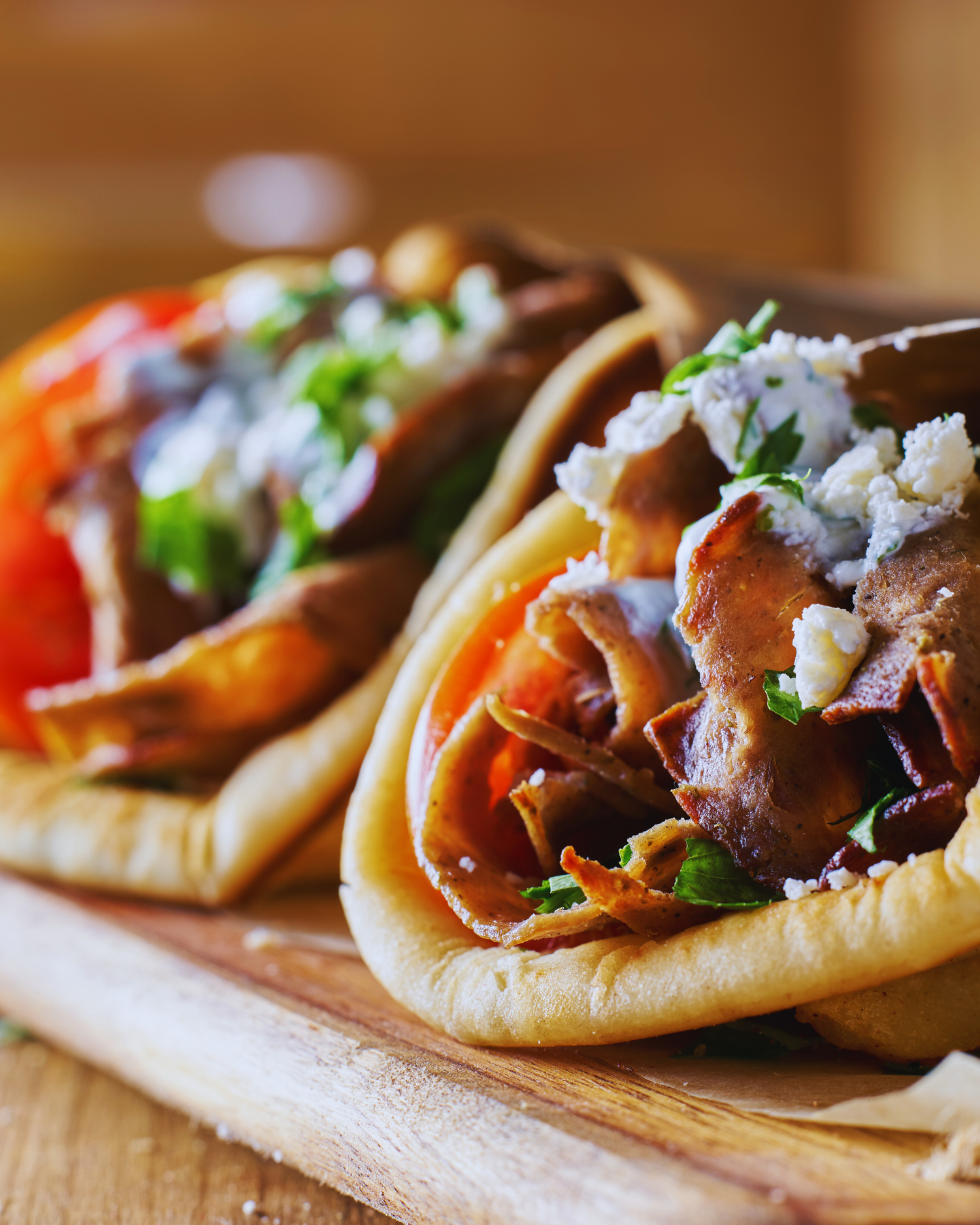 Frisch gefülltes Pita-Brot mit Gyrosfleisch, Tomaten, Zwiebeln und Tzatziki – beliebtes Streetfood aus der griechischen Küche.