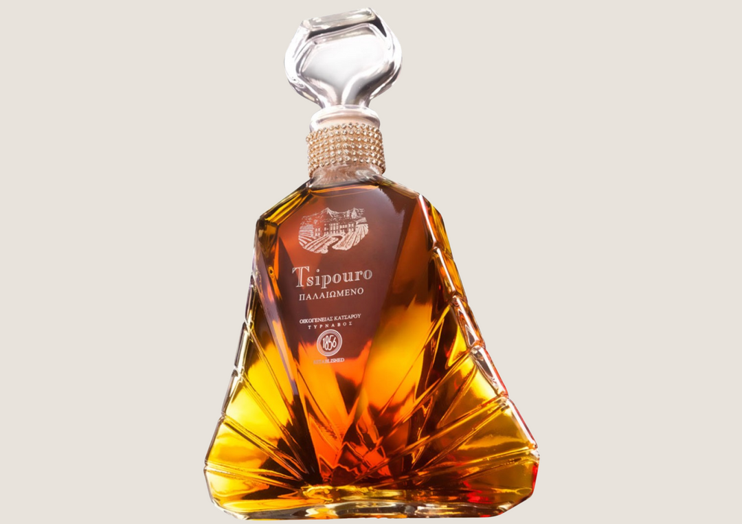 Edle Flasche Tsipouro mit bernsteinfarbener Spirituose in elegantem, facettiertem Glasdesign.