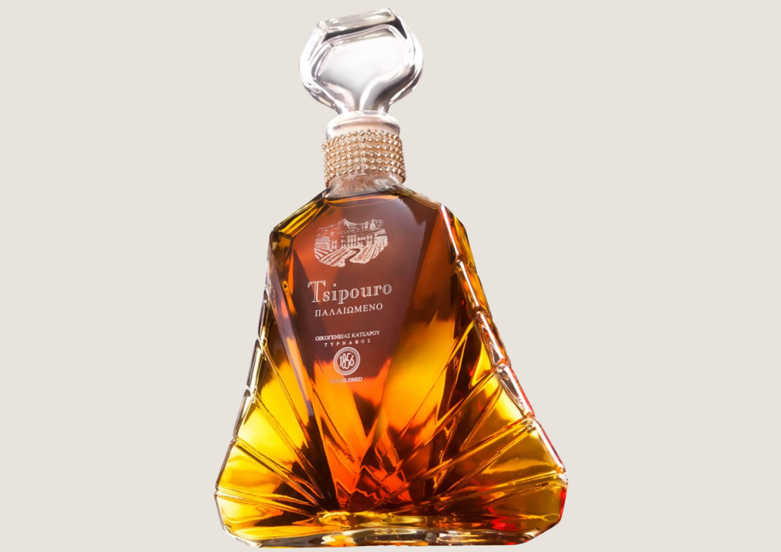 Edle Flasche Tsipouro mit bernsteinfarbener Spirituose in elegantem, facettiertem Glasdesign.